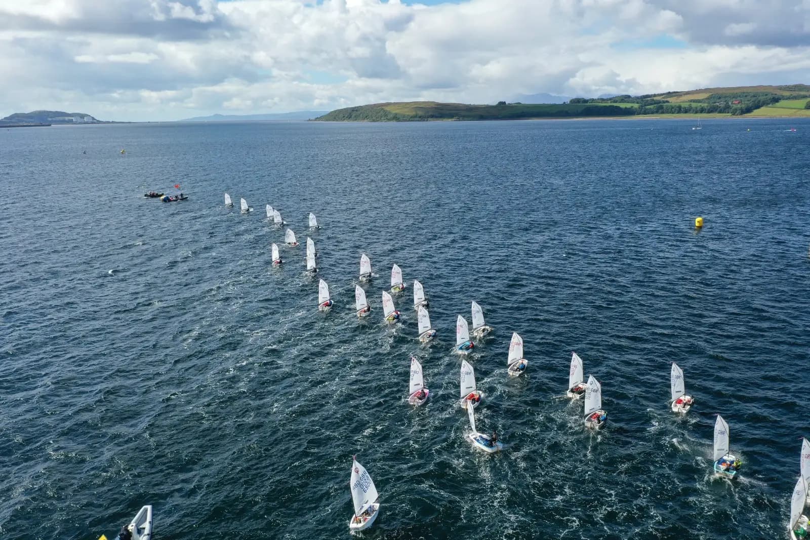 An Optimist fleet racing upwind, seen from above