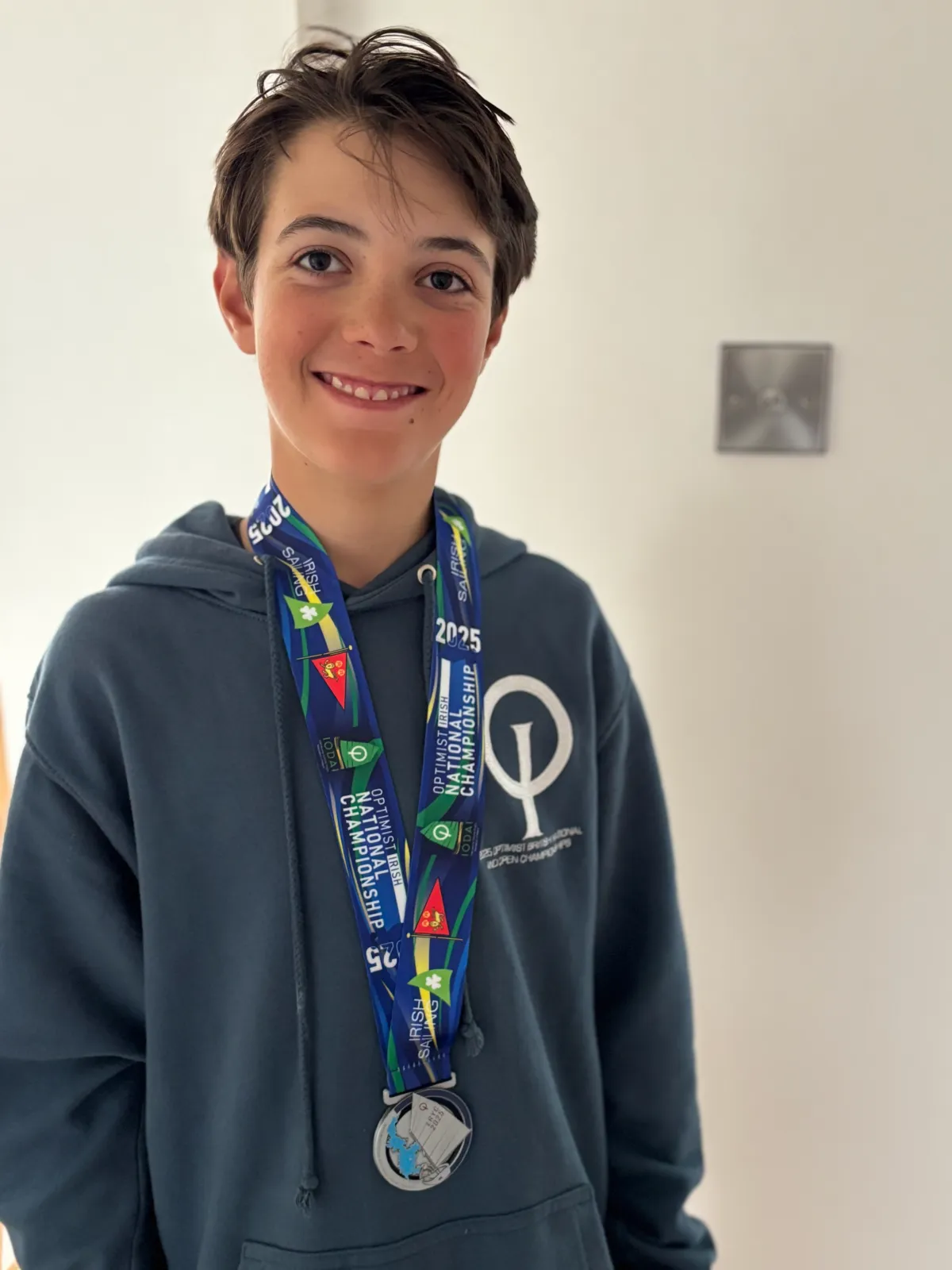 Finley Browne wearing his 2025 Irish Optimist National Championship medal